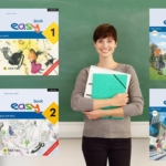 Lehrerin vor einer Kreidetafel mit den Covers von easy 1 bis easy 4 links und rechts von ihr